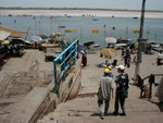 Heading down a "ghat" to the Ganges, officially as well as popularly called the Ganga. From time immemorial the holy river of the Hindus. The Ganges, personified as a goddess, originally flowed only in heaven until she was brought down by Bhagiratha to purify the ashes of his ancestors. She came down reluctantly, cascading first on the head of Shiva, in order to break her fall, which would have shattered the Earth. 