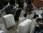 This is how you must prepare a parcel for mailing in India.  A tailor-like fellow covers it in muslin. . . 